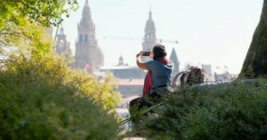 Kadın hacı Santiago de Compostela, St James Yolu sonunda İspanyol kasabasında cep telefonu ile kilisenin fotoğraf çekmek. Akıllı telefonda fotoğraf çekimi kadın, cep telefonu