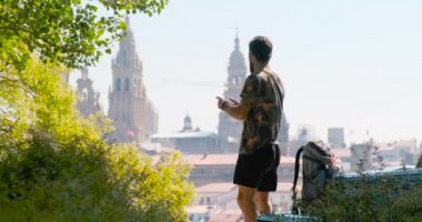 Erkek hacı Santiago de Compostela, St James Yolu sonunda İspanyol kasabasında cep telefonu ile katedral fotoğraf çekmek. Akıllı telefonda resim çekim genç adam, cep telefonu