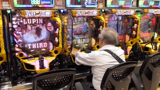 2019年7月 アジアのカジノでパチンコ 宝くじ アーケードゲーム ビデオゲーム ビデオゲーム ギャンブル スロットマシンをプレイする日本人男性 アジア — ストック動画
