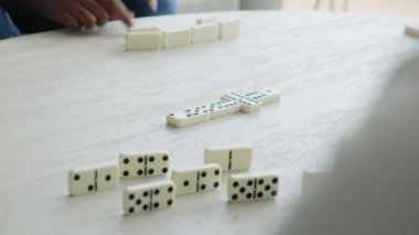 Evde domino oynayan çok ırklı bir çift. Afro-Amerikalı eş ve beyaz koca gülümsüyor ve oyunla eğleniyorlar. Rahatla ve mutlu partnerlerle vakit geçir. Ellerin yakın çekimi