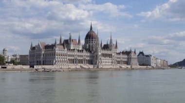 Macaristan Parlamentosu 'nun dış manzarası, Macaristan' ın Budapeşte kentindeki Tuna nehrinin kıyısındaki Ulusal Meclis 'in merkezi. Nehir gezisinde feribottan görülen ünlü siyaset ve turizm anıtı.