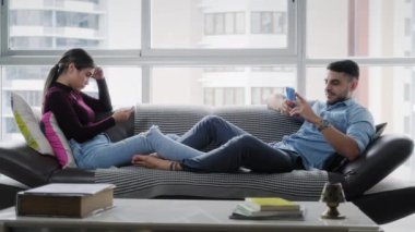 Evde akıllı telefonu olan genç bir çift. Kadın ve erkek birbirlerini görmezden geliyorlar, cep telefonu kullanıyorlar. Kanepede cep telefonu olan karı koca. Sıkılmış ortaklar ve yaşam tarzı
