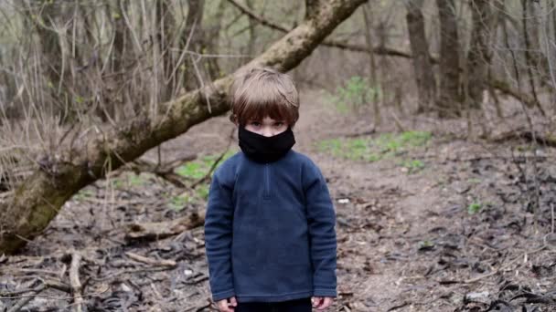 Jonge jongen 4 jaar oud in het bos met zwart medisch masker van Covid-19 virus — Stockvideo