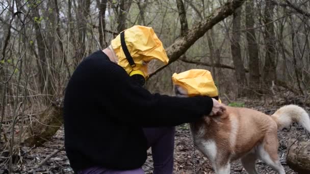 Muž držící svého psa Huskeyho ve žluté radiační masce, koncepce koronaviru — Stock video
