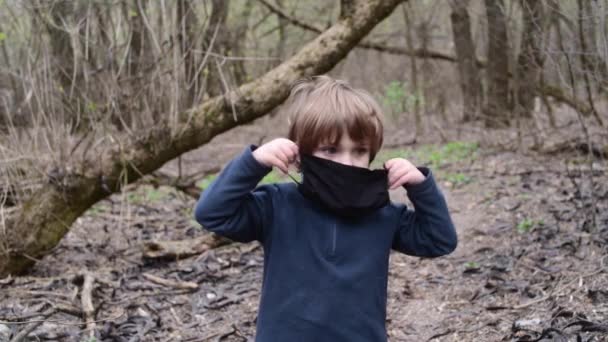 Een jongen die naast een bos staat — Stockvideo