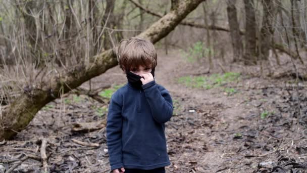 4-jähriger Junge im Wald mit schwarzer medizinischer Maske gegen Covid-19-Virus — Stockvideo