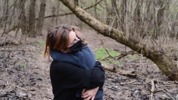 Junge Frau und Sohn stehen mit schwarzer medizinischer Maske vor dem Covid-19-Virus im Wald — Stockvideo