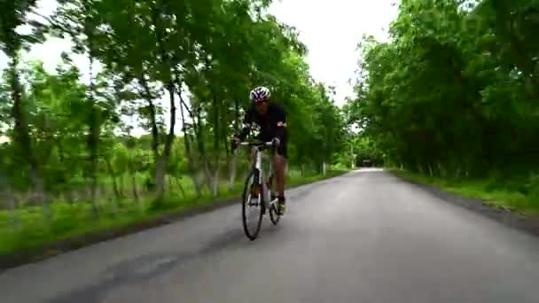 Triatleta professionista ciclismo su strada, concetto di sport, tramonto su strada in montagna — Video Stock