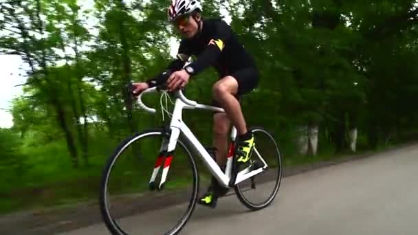 Profi sportoló kerékpározás közúti kerékpár, sport koncepció, hegyi út naplementekor — Stock videók