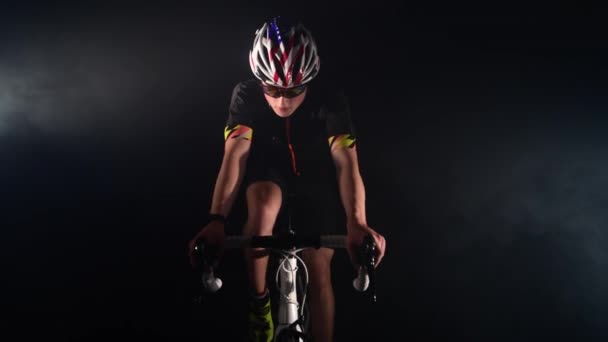 Pro triatleta ciclismo bicicleta de carretera, concepto de deporte, fondo negro y humo — Vídeos de Stock