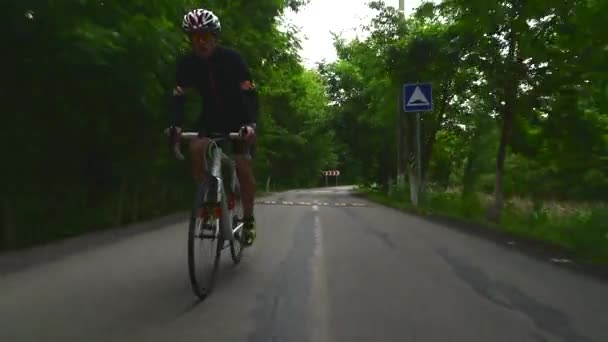 Pro cyklist cykel, sport koncept, bergsväg vid solnedgången — Stockvideo