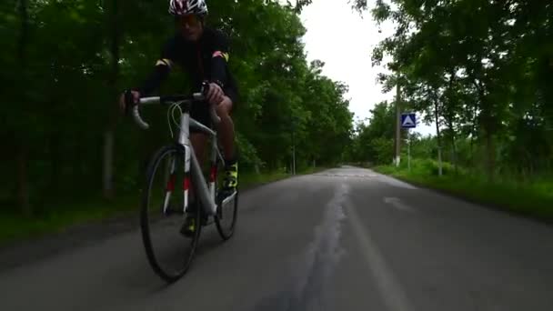 Professionell idrottsman cykling väg cykel, sport koncept, bergsväg vid solnedgången — Stockvideo