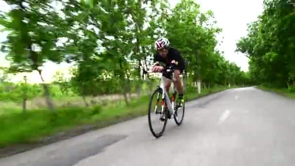 Профессиональный триатлонист велосипедный дорожный велосипед, спортивная концепция, закат горной дороги — стоковое видео