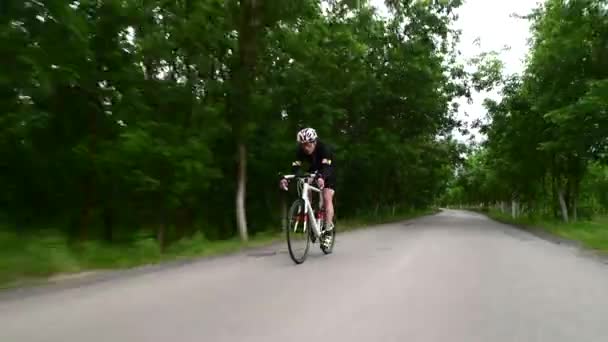 Triatleta professionista ciclismo su strada, concetto di sport, tramonto su strada in montagna — Video Stock