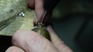 Kuyumcu altın alyansa elmas takar. El işi mücevherler.