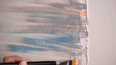 Genç kadın sanatçı soyut resim çiziyor, pastel renkler akrilik boya.