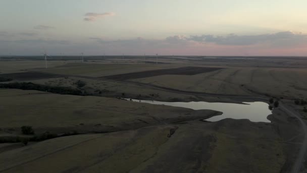 Vista aérea del paisaje de los molinos de viento, generadores eólicos para la producción de energía en la puesta del sol. Turbinas eólicas generadoras de energía renovable limpia para el desarrollo sostenible — Vídeo de stock