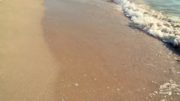 Genç kadın bacakları beyaz kumda yürüyor. Adanın sahilinde dalgalar var. Sinematik. — Stok video