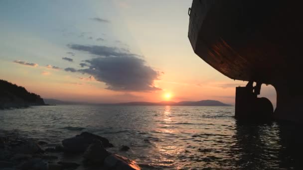 Kargo gemisi gün batımında karaya oturmuş kumsal sürüsünde bekliyor. — Stok video