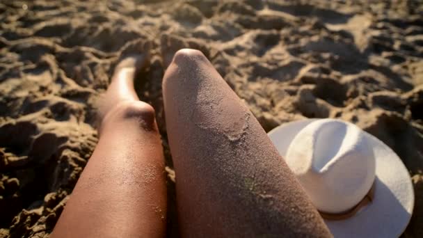 Giovane ragazza prendere il sole sulla spiaggia di sabbia bianca con onde in spiaggia, 4k cinema — Video Stock