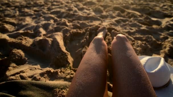 Chica joven tomando el sol en la playa de arena blanca con olas en la playa, 4k cinemática — Vídeo de stock