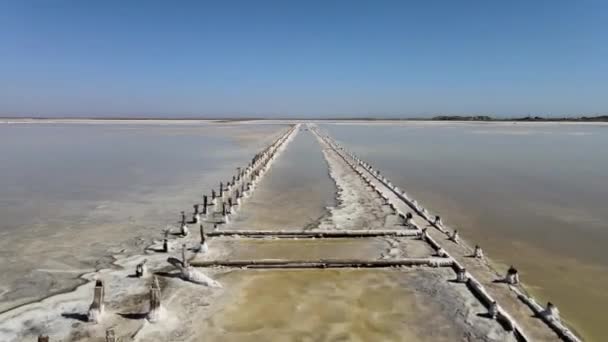 Verlaten pier op veelkleurige meer geneeskrachtige klei ongegradeerd op zonsondergang, lucht drone view — Stockvideo