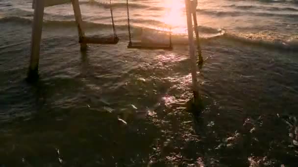 閉じる夕日の波の間に海でヴィンテージ空の空気スイング。リラックス4kビデオ — ストック動画
