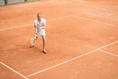 Eski usul tenis oyuncu ahşap raket ve top kahverengi sahada eğitim