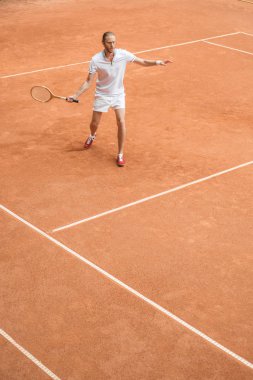 Eski usul tenis oyuncu kahverengi kortta retro ahşap raket ile eğitim
