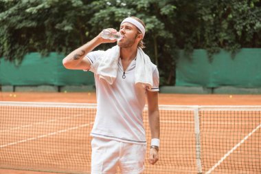 Retro yorgun tenisçi havlu içme suyu ile tenis kortunda tarz.