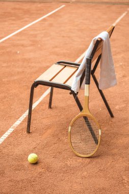 sandalye tenis topu, retro ahşap raket ve tenis kortunda havlu ile kapatın
