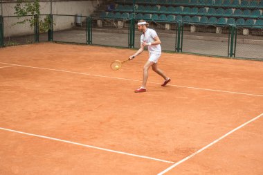 beyaz spor tenis raket ve top oynarken sahada adam retro tarz