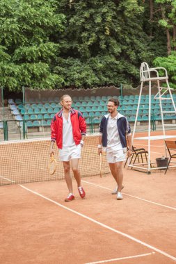Eski-fashionedfriends tenis kortunda yürüyüş Ahşap raketler ile