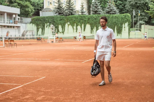 テニスコート トレーニング後バッグを歩いて昔ながらのテニス選手 — ストック写真