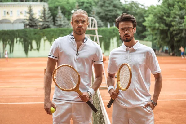 严肃的网球运动员与木球拍和球摆在比赛以后在法院 — 图库照片