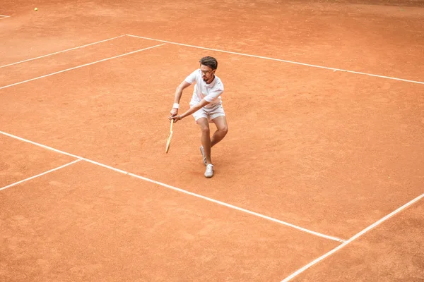 Tenis kortunda oyun oynarken raket ile erkek tenisçi retro tarz