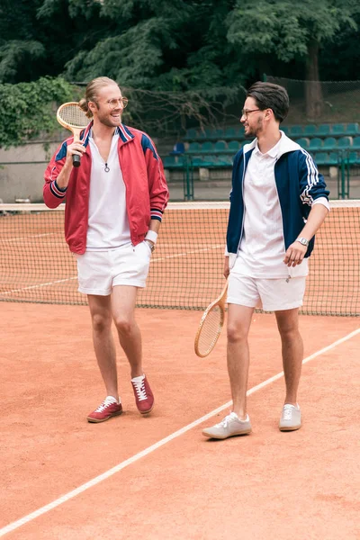 neşeli sportif arkadaş Ahşap raketler tenis kortunda yürüyüş grubu