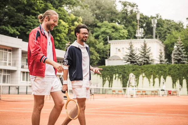 Lachende Vrienden Met Houten Rackets Lopen Tennisbaan — Stockfoto