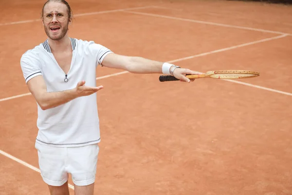 worried emotional tennis player pointing with racket on tennis court