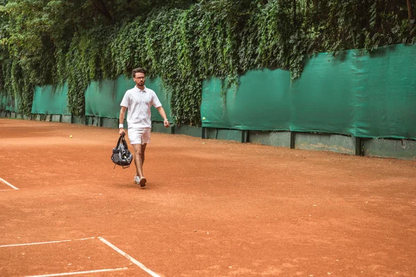 Sportler im Retro-Stil geht mit Tasche nach dem Training auf dem Tennisplatz — Stockfoto