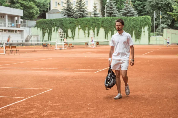 Jogador de tênis old-fashioned andando com saco após o treinamento no campo de ténis — Fotografia de Stock