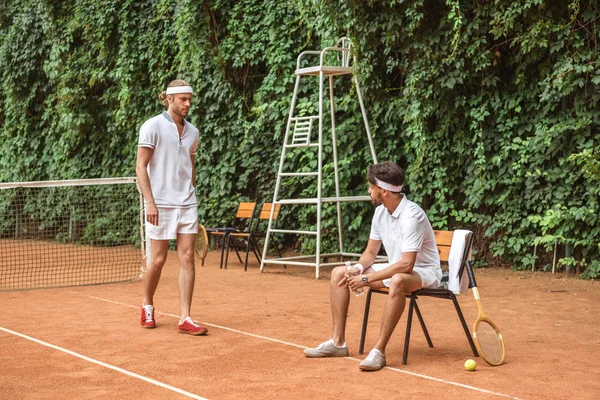 Joueurs de tennis à l'ancienne en vêtements de sport blancs sur le terrain — Photo de stock