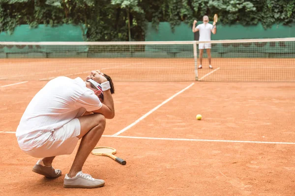 Jugador de tenis frustrado después de fallar en la cancha de tenis marrón - foto de stock