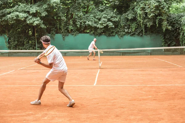 Esportistas jogando tênis com raquetes de madeira na quadra juntos — Fotografia de Stock