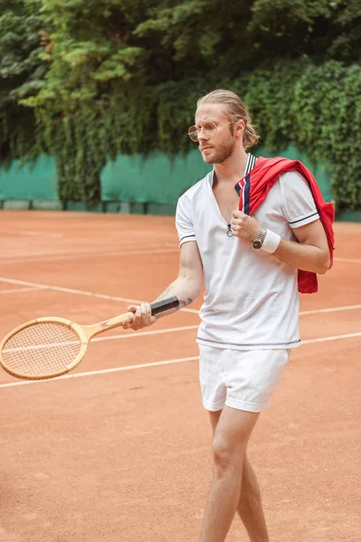 Handsome tennis player with retro wooden racket on court — Stock Photo
