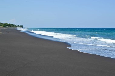 Siyah volkan kum plaj ve Bali Adası'nın Doğu maliyet mavi Hint Okyanusu'nda