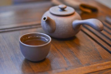 Çin çay servisi çay için: ahşap stand, bir çay ve çaydanlık kolu yakın çekim ile kil Kupası