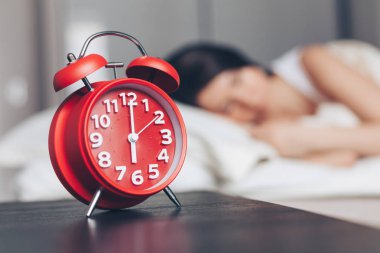 Çalar saat kapanıyor ve genç bayan yatak odasında uyuyor.