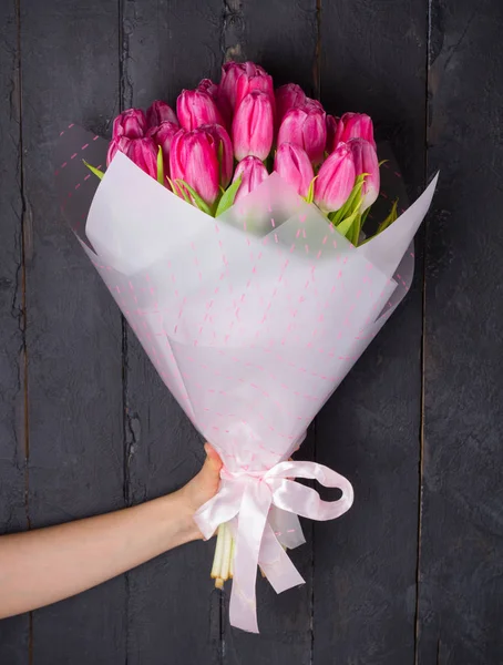 Mujer Mano Sosteniendo Ramo Tulipanes Flores Embalaje Sobre Fondo Madera —  Fotos de Stock