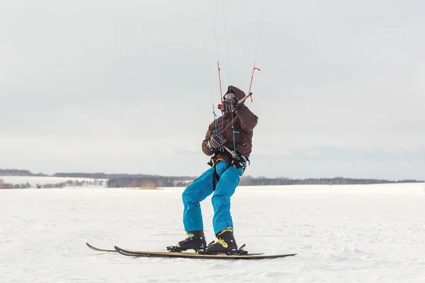 Лыжник идет на снежное поле с воздушным змеем — стоковое фото